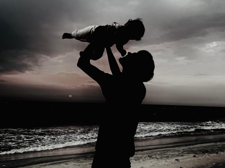 Me lifting my daughter by the beach